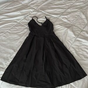 Elegant black dress with pockets, crisscross strap in the back adjustable.